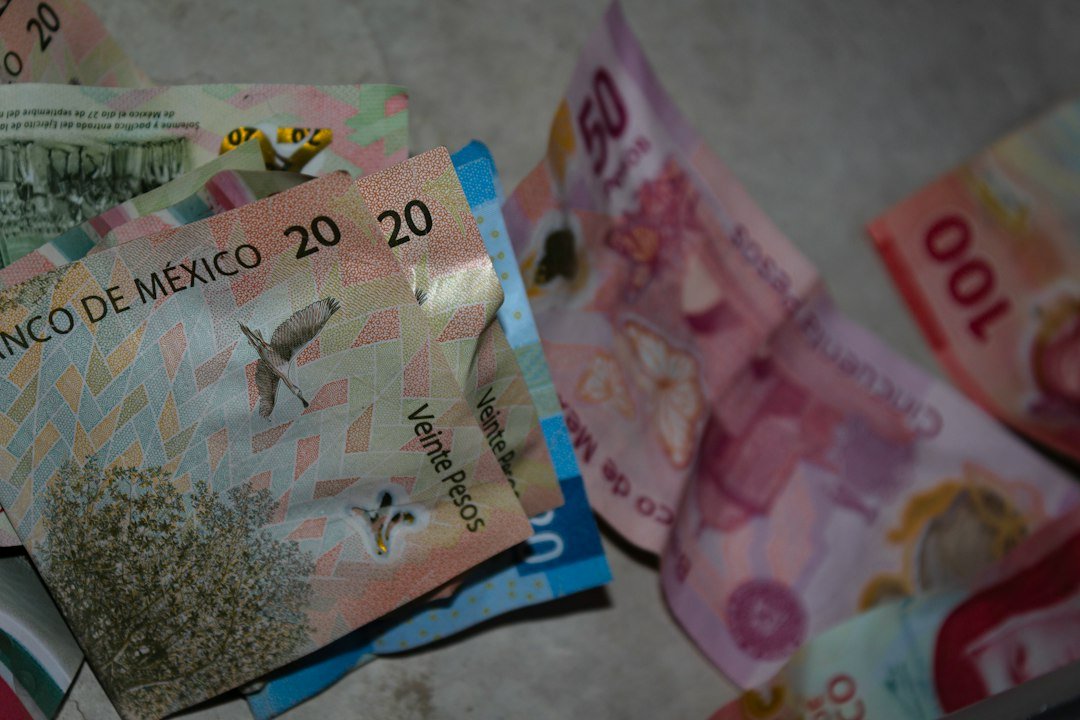 Billetes de pesos mexicanos de distintas denominaciones sobre una mesa, representando el pago del aguinaldo