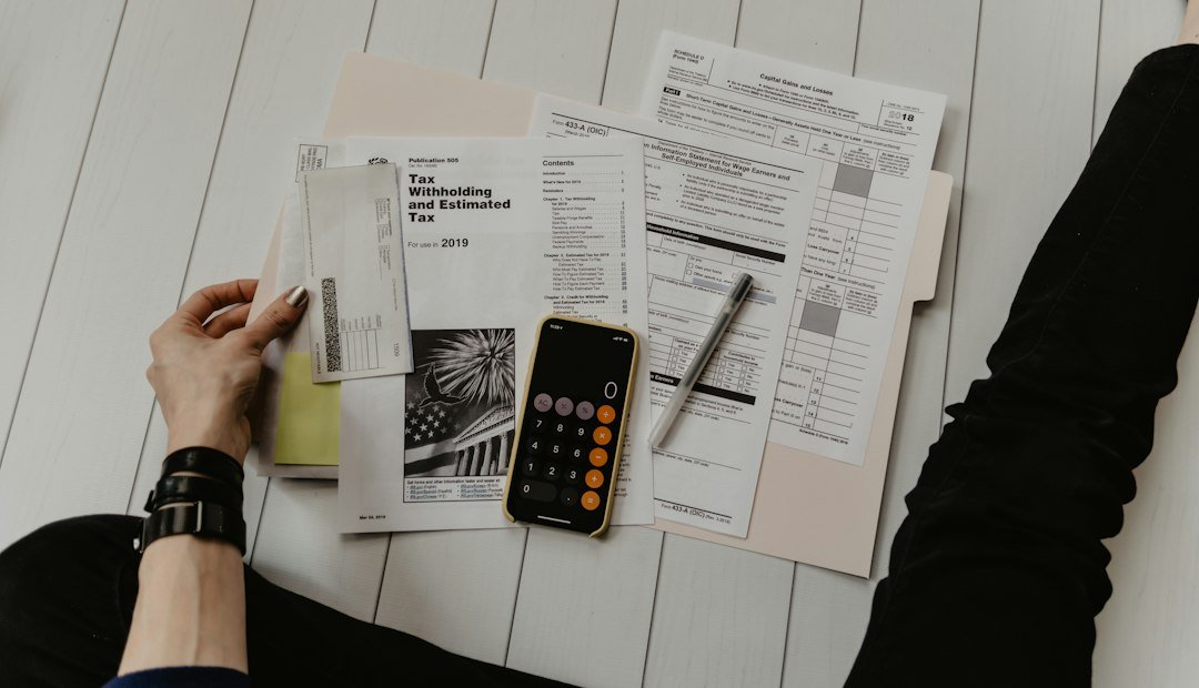 Persona revisando documentos y calculando montos con una calculadora, representando el cálculo del retiro parcial por desempleo de la AFORE
