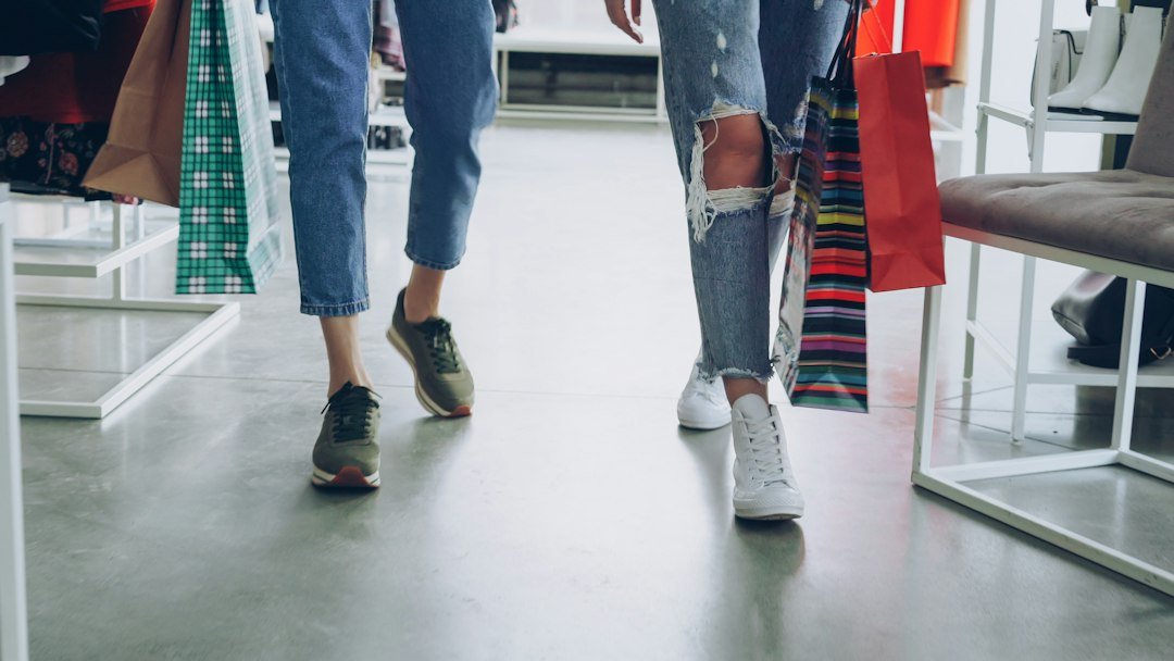 Dos personas caminan con bolsas de compras